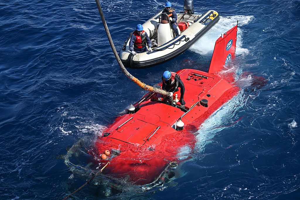 潜航员为“深海勇士”号载人潜水器解开与“探索一号”科考船相连的缆绳，为“深海勇士”号载人潜水器下潜做准备（5月26日摄）。新华社记者 蒲晓旭 摄