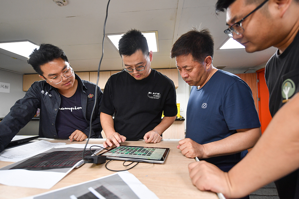 考古队员在“探索一号”科考船上查看从水下采集的考古数据（5月24日摄）。新华社记者 蒲晓旭 摄